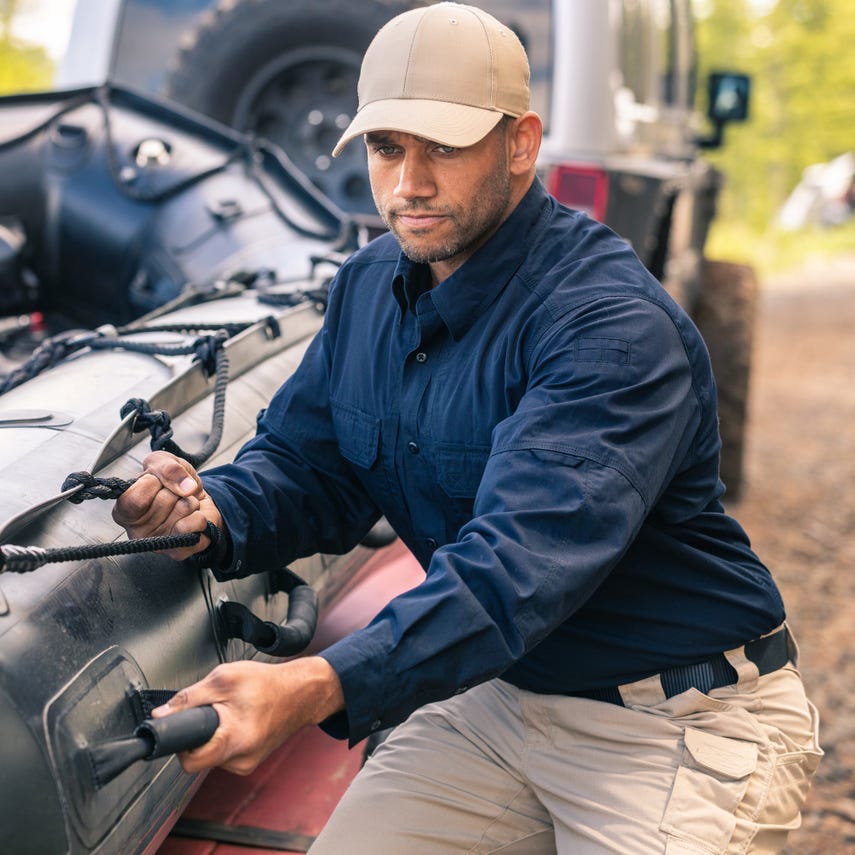 Man wearing 5.11 Tactical Taclite® Uniform Cap, working outdoors with equipment, showcasing durability and functionality.